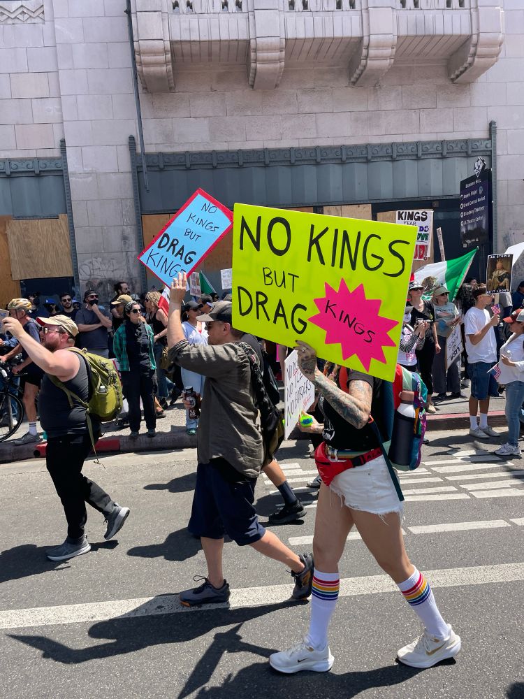 marchers on the street during the day holding no king signs