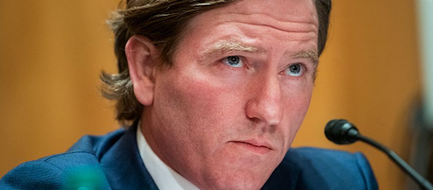 A Getty Images photo of Chris Krebs from 2020, seen seated in front of a microphone testifying to Congress.