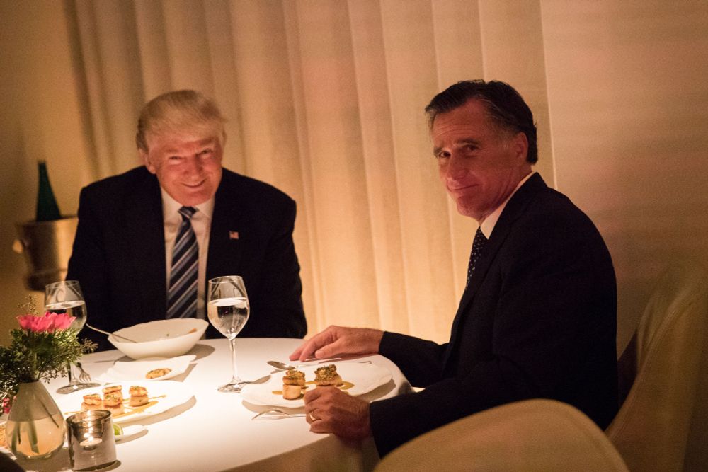 Donald Trump and Mitt Romney at dinner, Trump with an unsettling grin looking directly at the camera, Romney turned over his shoulder with a look of resignation and humiliation; the lighting is out of "Twin Peaks" 