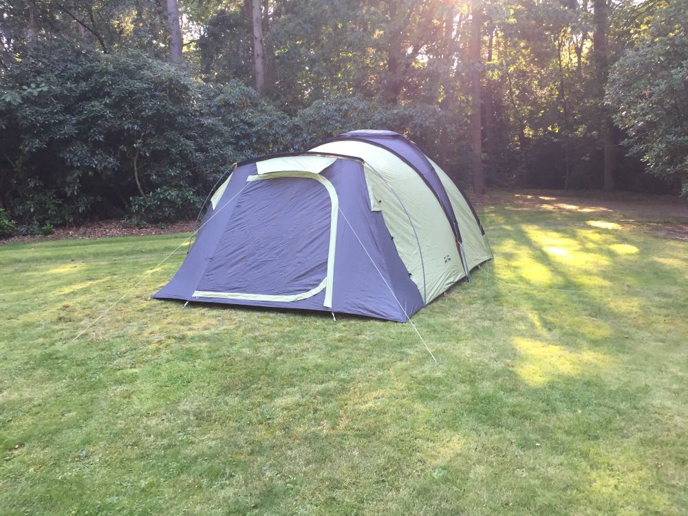 Een tent staat op een grasveld. 