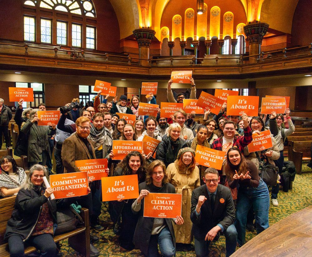 A group of Joel's supporters gather in Dominion Chalmers with signs that feature various campaign slogans