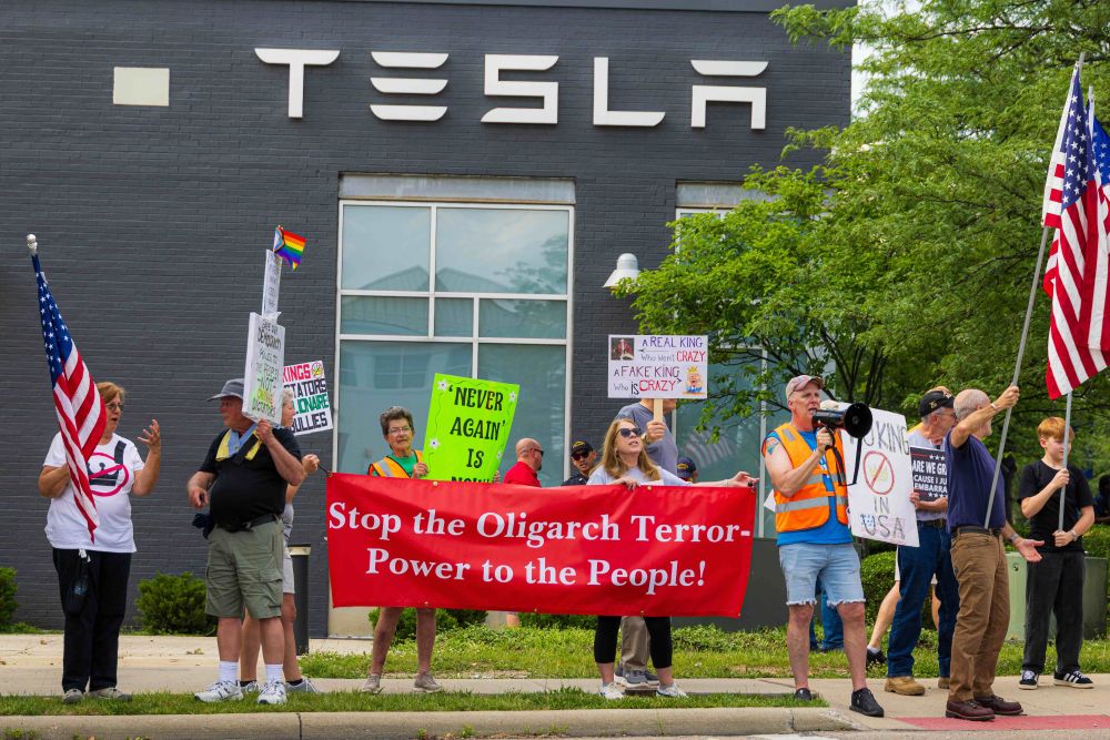 Protesters outside the Easton Tesla in Columbus; sign says, Stop the Oligarch Terror - Power to the People! Protesters gather every Saturday at 4:30 PM.