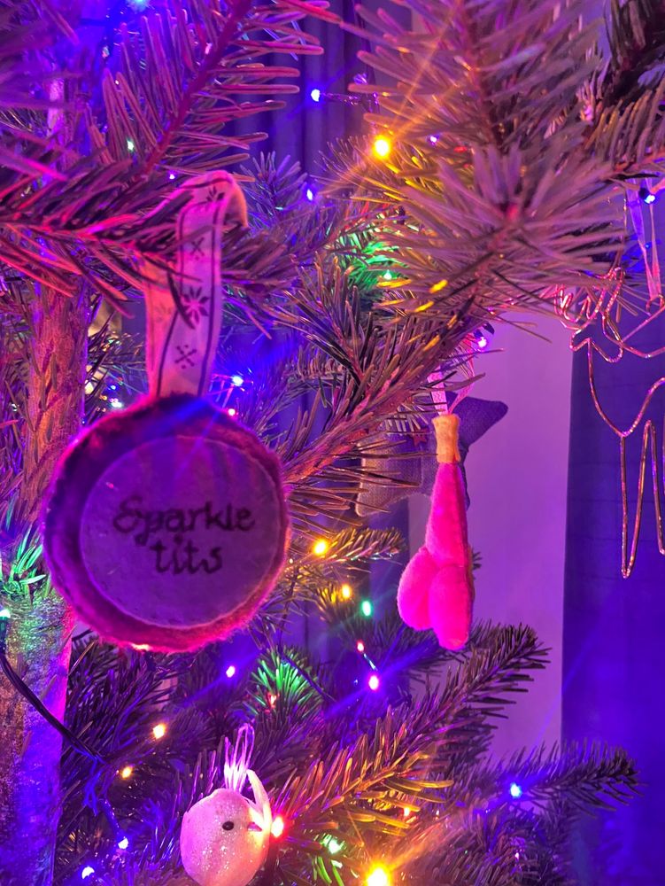 Christmas tree with purple felt bauble stitched with ‘sparkle tits’ on one side and a boob on the other side. 