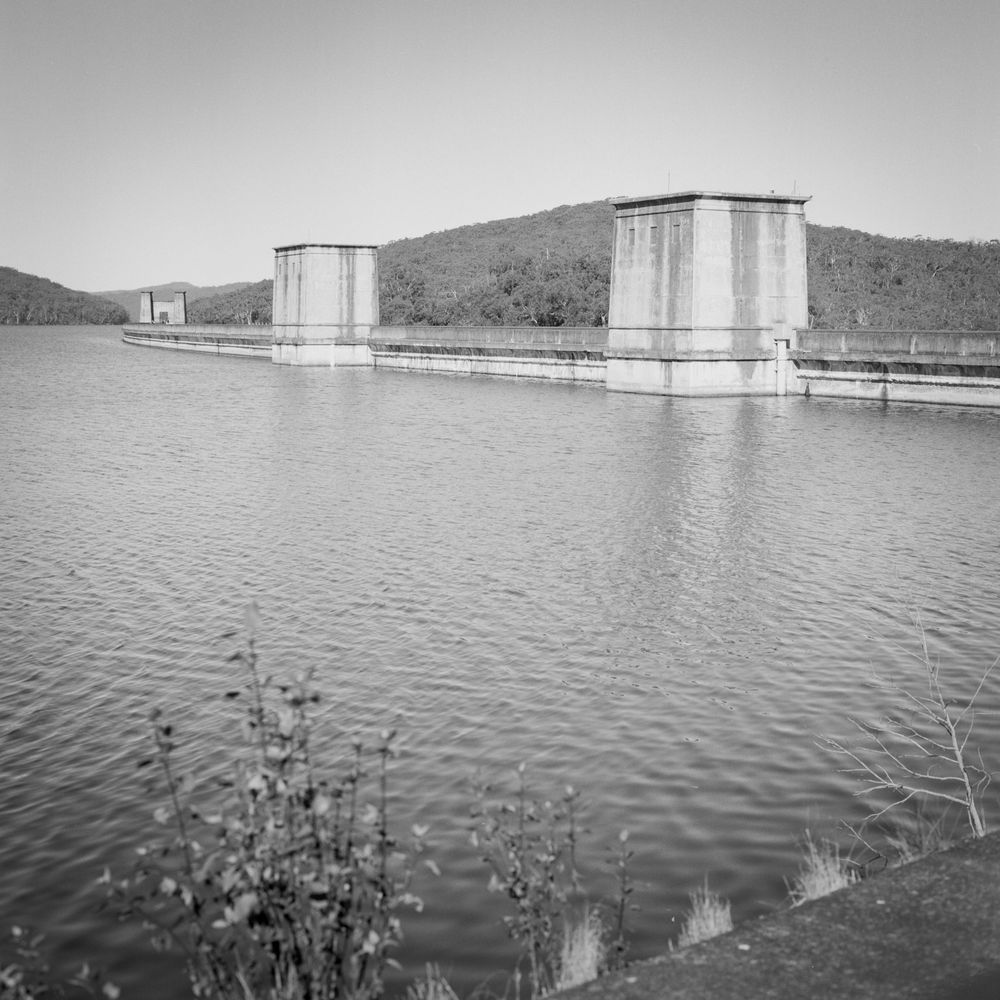 Black and white medium format film photo of the catchment area, the dam wall and it's iconic concrete structures in shot.