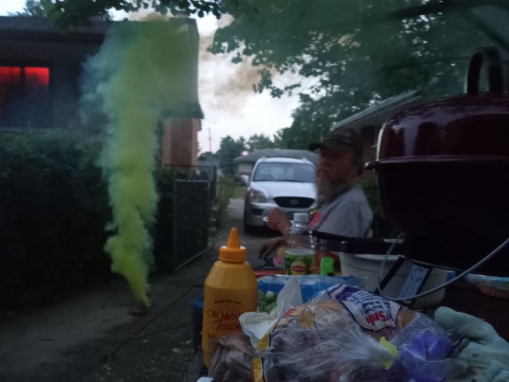 we were having a 4 of july cookout, dad's in the background, but his face is blurry, we're setting off colored smokers.
