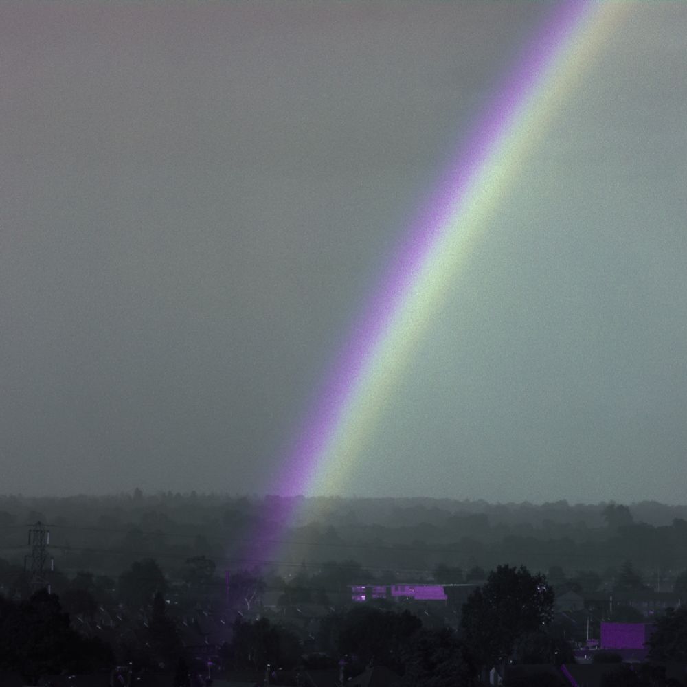An ultraviolet picture of a rainbow: a dark, foreboding landscape with a deep purple stripe emanating from it, and a grey stripe inside