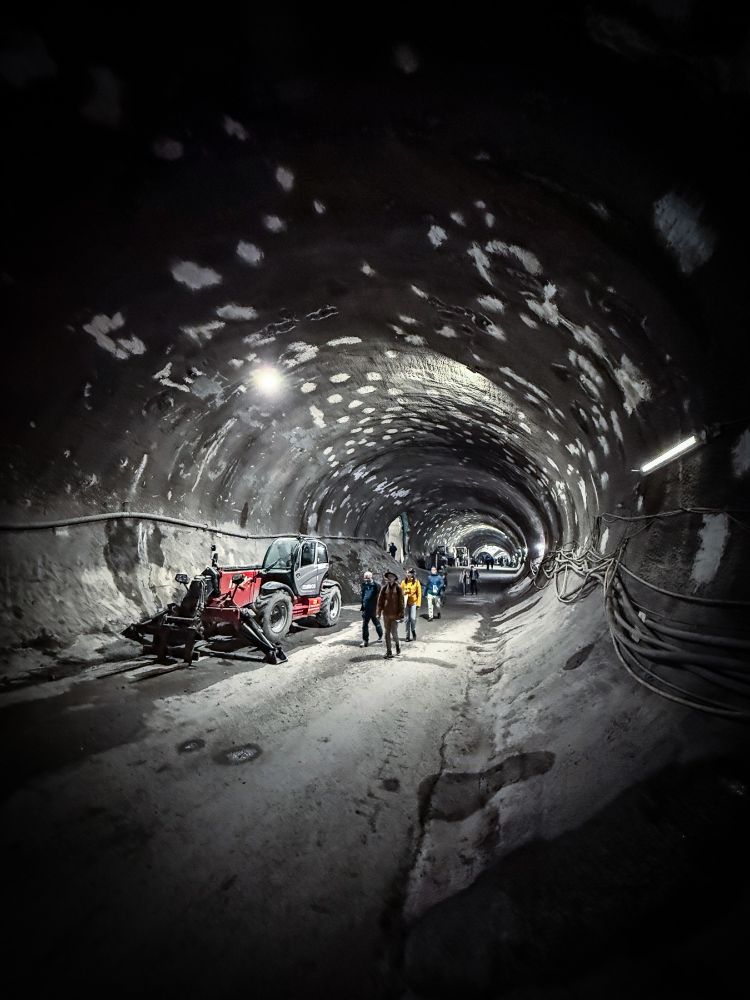 Photo of people walking and construction machines in metro subway construction project