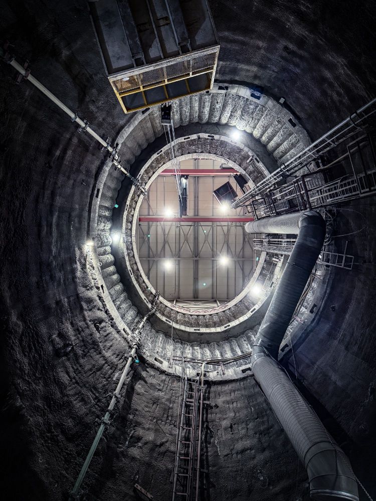 Photo looking up at massive shaft in earth towards roof from metro subway construction project