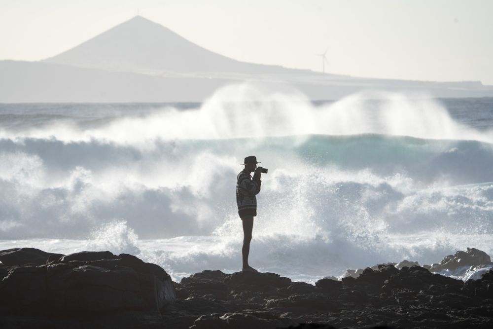 Man taking photos of waves