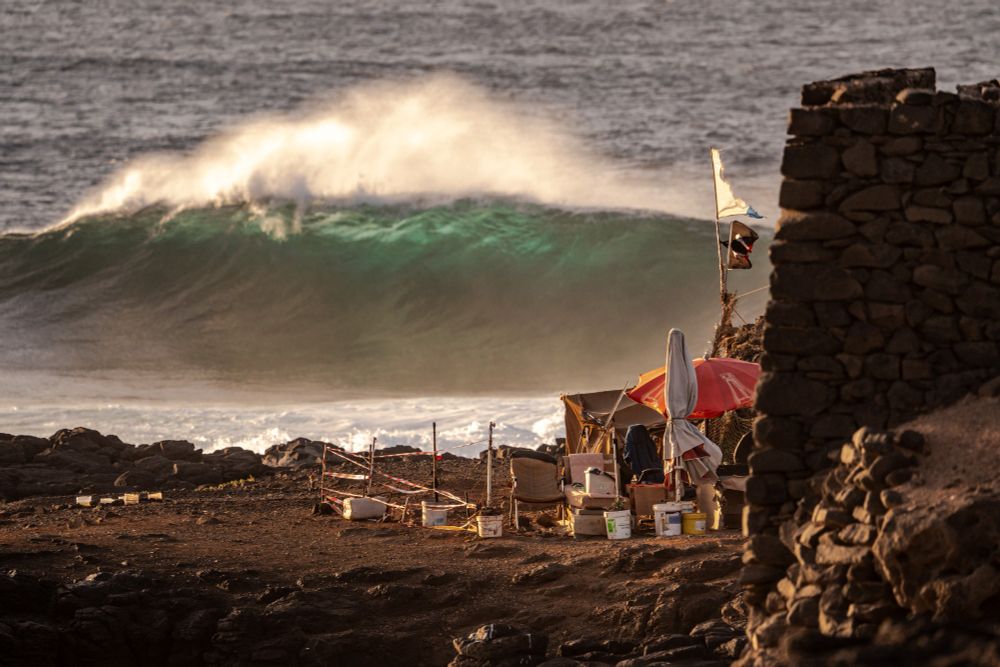 Massive wave crashing with living hut in foreground