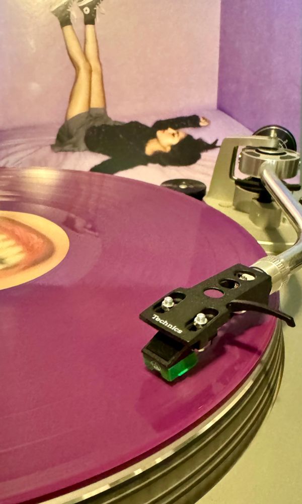 A purple Olivia Rodrigo record playing on a turntable. 