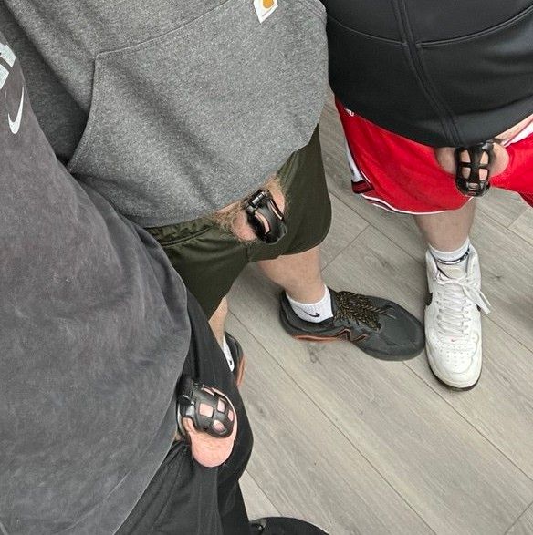 Three guys in hoodie vs shorts, all locked in chastity cages. 