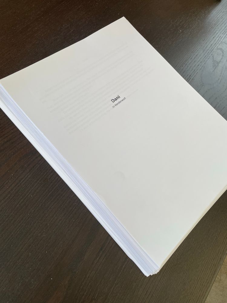 Picture of stack of papers with title page on top sitting on a table 