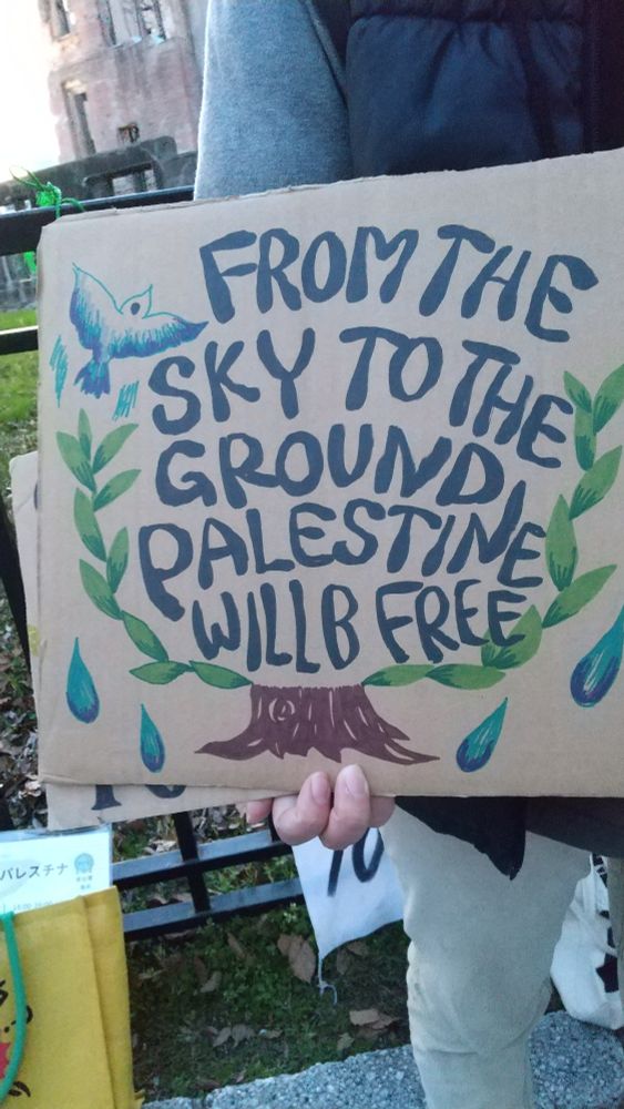 段ボールに「FROM THE SKY TO THE GROUND PALESTINE WILL B FREE」と書いてある