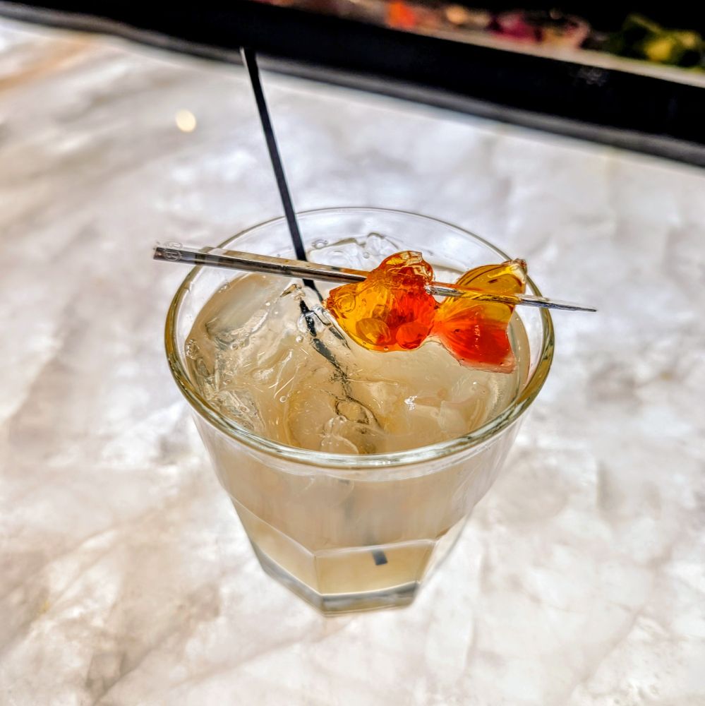 A mocktail with a gummy goldfish garnish