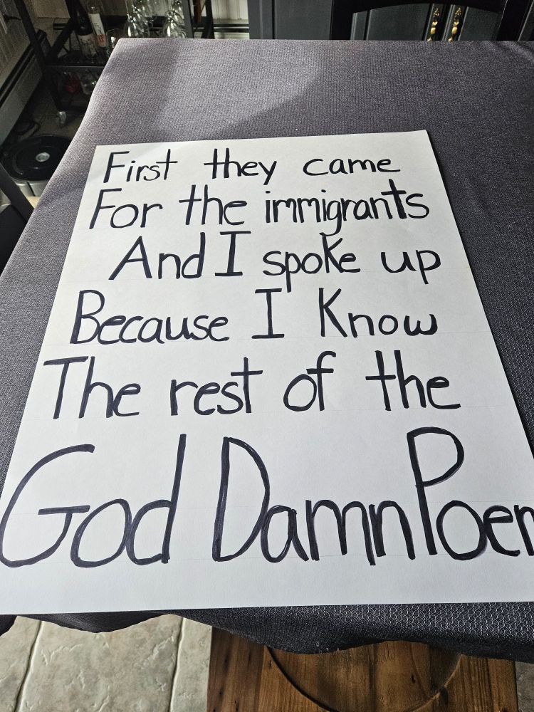 Sign saying `First they came for the immigrants and I spoke up because I know the rest of the god damn poem