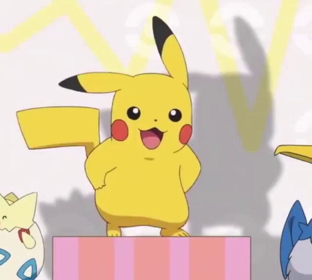 a pikachu standing on top of a pink and white striped box