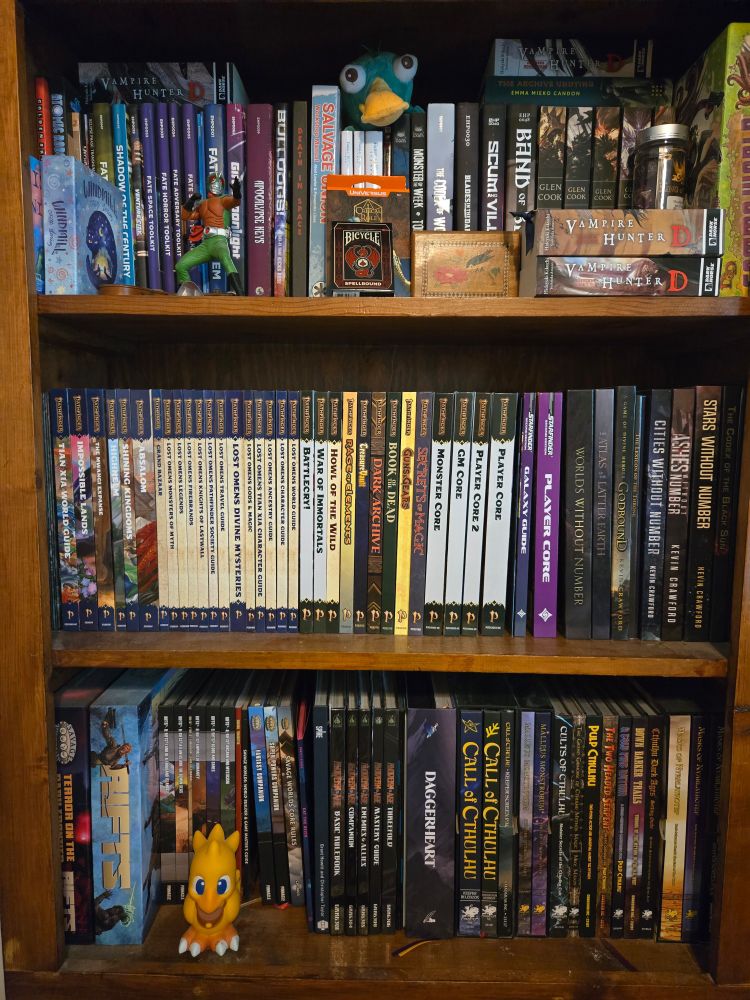 A bookshelf filled with tabletop role-playing games in a handful of fantasy and sci-fi novels