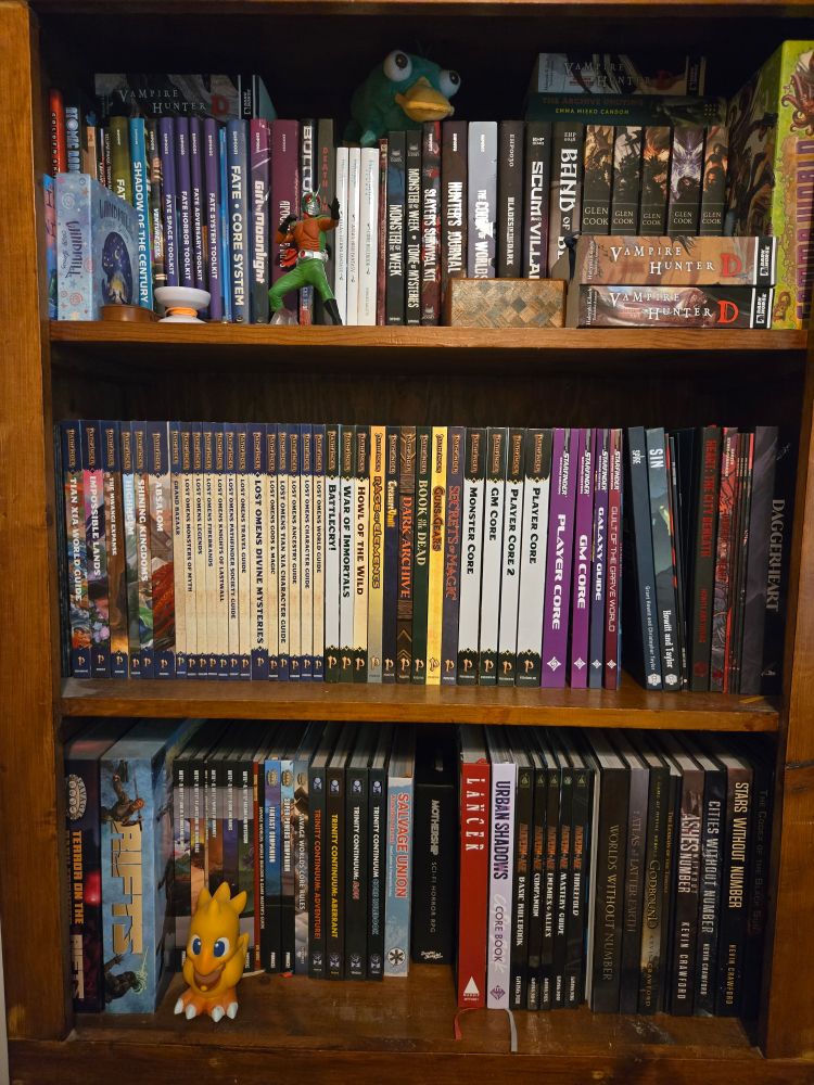 A bookshelf with lots of tabletop games a couple of novels some figurines and a lone yo-yo. It is quite a collection.