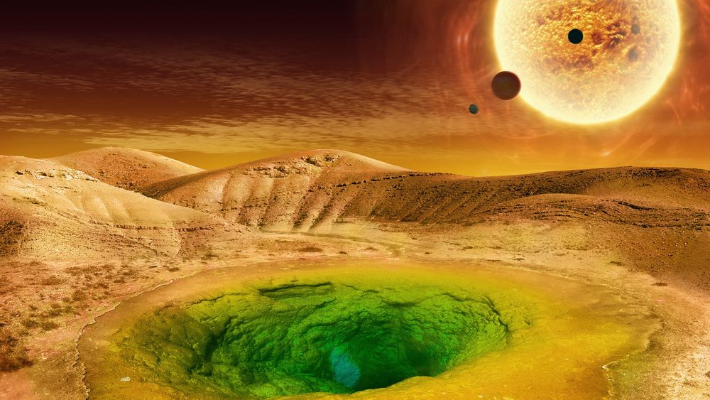 Artist’s conception of what life could look like on the surface of a rocky exoplanet. A planetary surface, similar to that of Mars or desert-regions of Earth, covers the image horizontally. The sky is a dark brownish orange-red, not dissimilar in colours of the surface. In the foreground, there is a green lagoon-looking pool, with an underwater cave visible beneath the clear water surface. In the background, in the sky, a close-up and seemingly active star (Sun) with three minor planetary bodies in front of it like moons.

Image credit: NASA