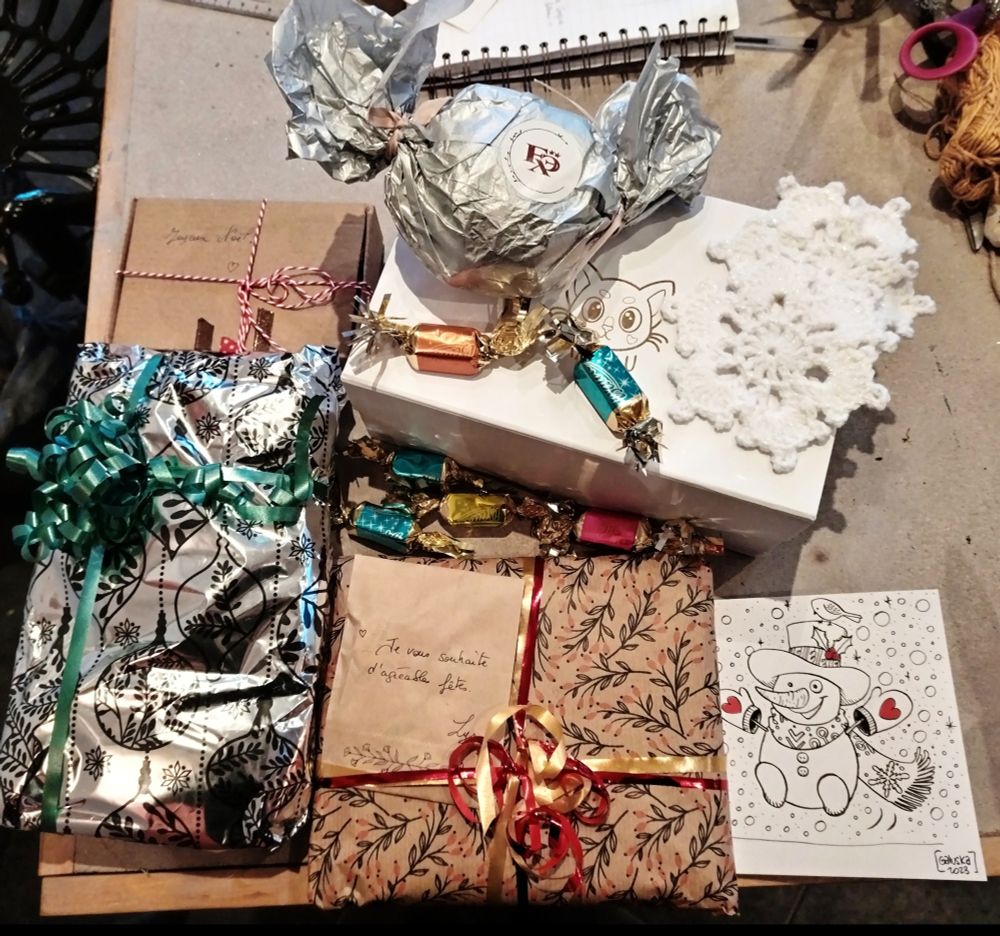 Cadeaux emballés de toutes les couleurs sur une table.