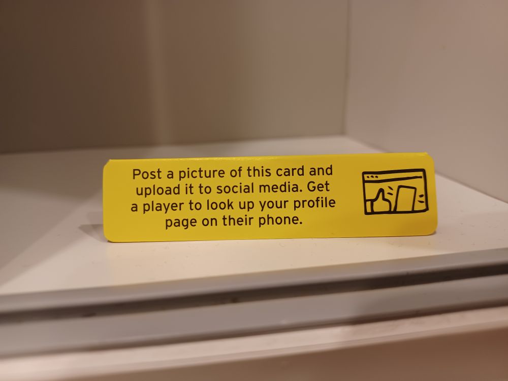 Picture of the card from the Don't Get Got! game saying "Post a picture of this card and upload it to social media. Get a plater to look up your profile page on their phone"