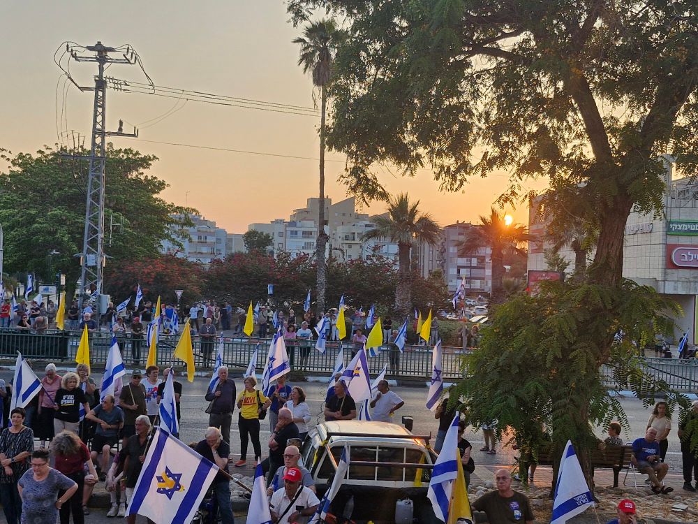הפגנה בנס ציונה, עם שקיעה. דגלי ישראל, צהובים