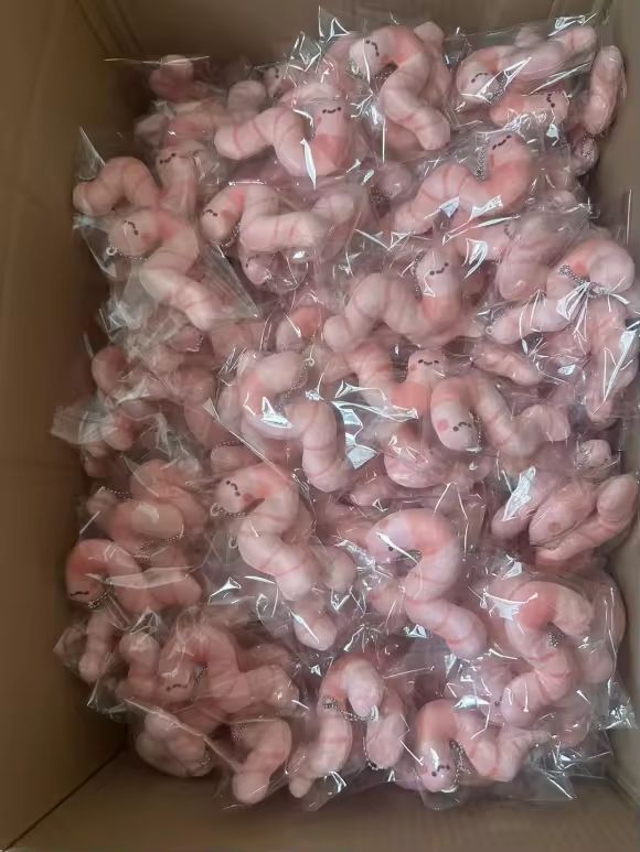 a box full of many plushies worms in clear plastic bags. it's a bit terrifying