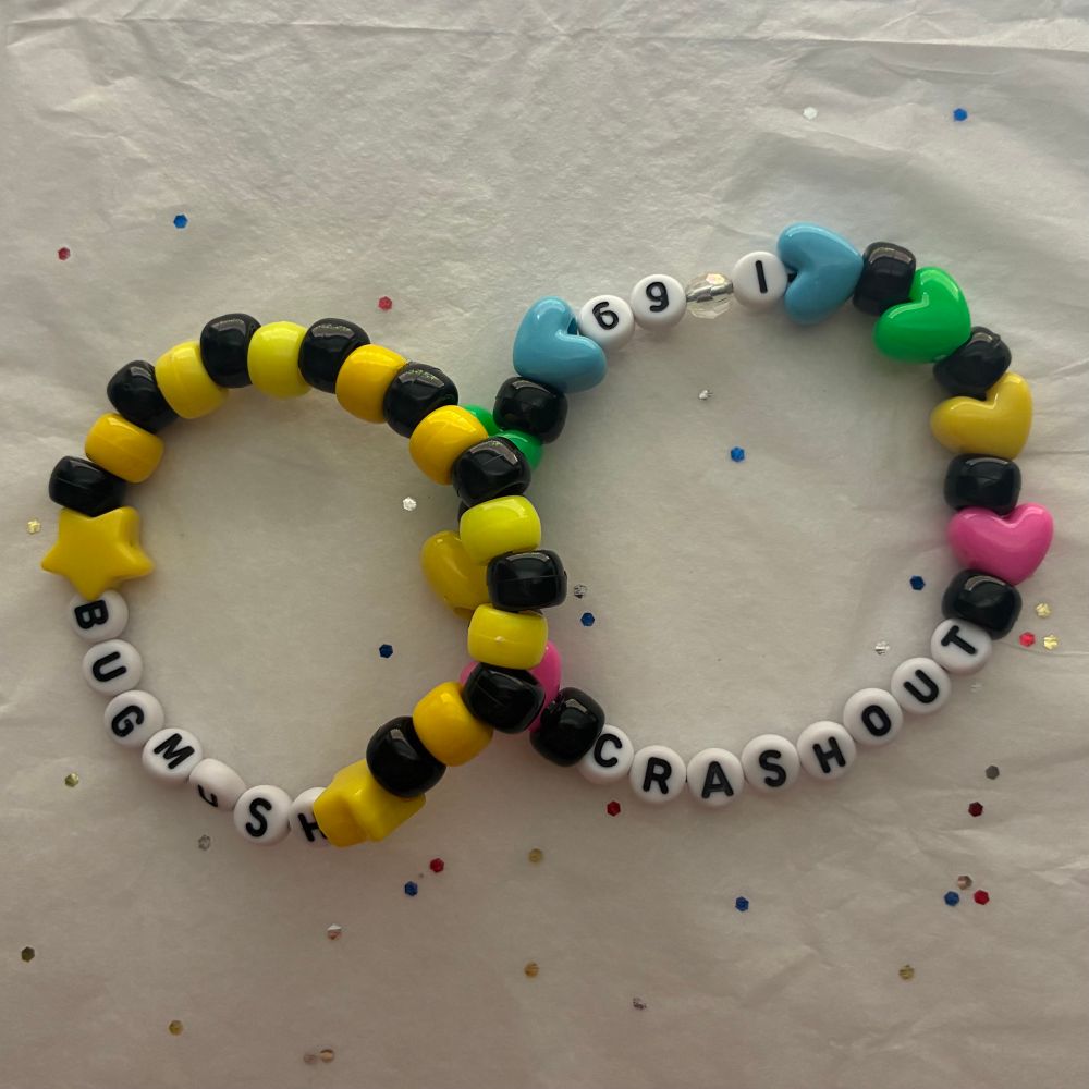 The two previous bracelets together in one photograph. The black and yellow bug mush bracelet is on the left and the multicolored crash out bracelet is on the right.