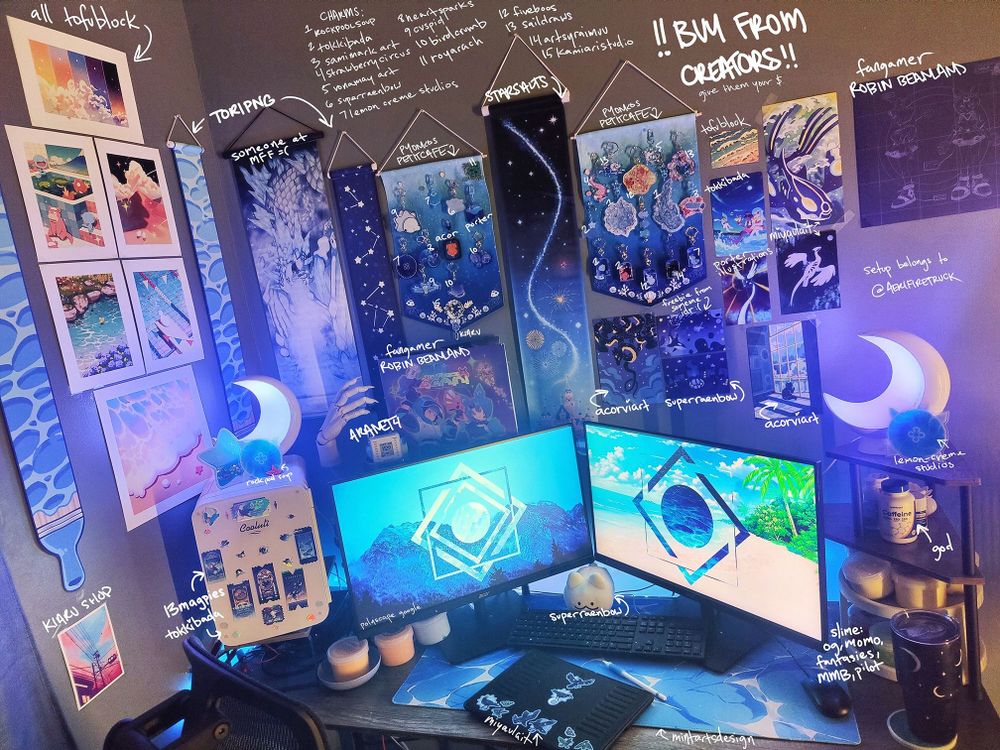 A very detailed picture of the artist's work desk setup.

There are two 27 inch monitors with blue polyscape backgrounds, a blue waves deskmat, a mini-fridge decorated with stickers to the left, and a multi-tier organizer to the right with a lamp, medication, and slime.

The walls are filled with various banners, prints, and decor, with lots of oceanic charms, enamel pins, popsicle liquid charms, and similar. Most accessories are blue or ocean-themed, with lots of recurring pokemon, stars/stargazing, moons, and sea creature motifs. The artist's ipad is in photo, decorated with blue magpie stickers. All artists (that the poster can find) are credited in handwritten text. In caps it reads within a blank space "BUY FROM CREATORS, GIVE THEM YOUR MONEY"