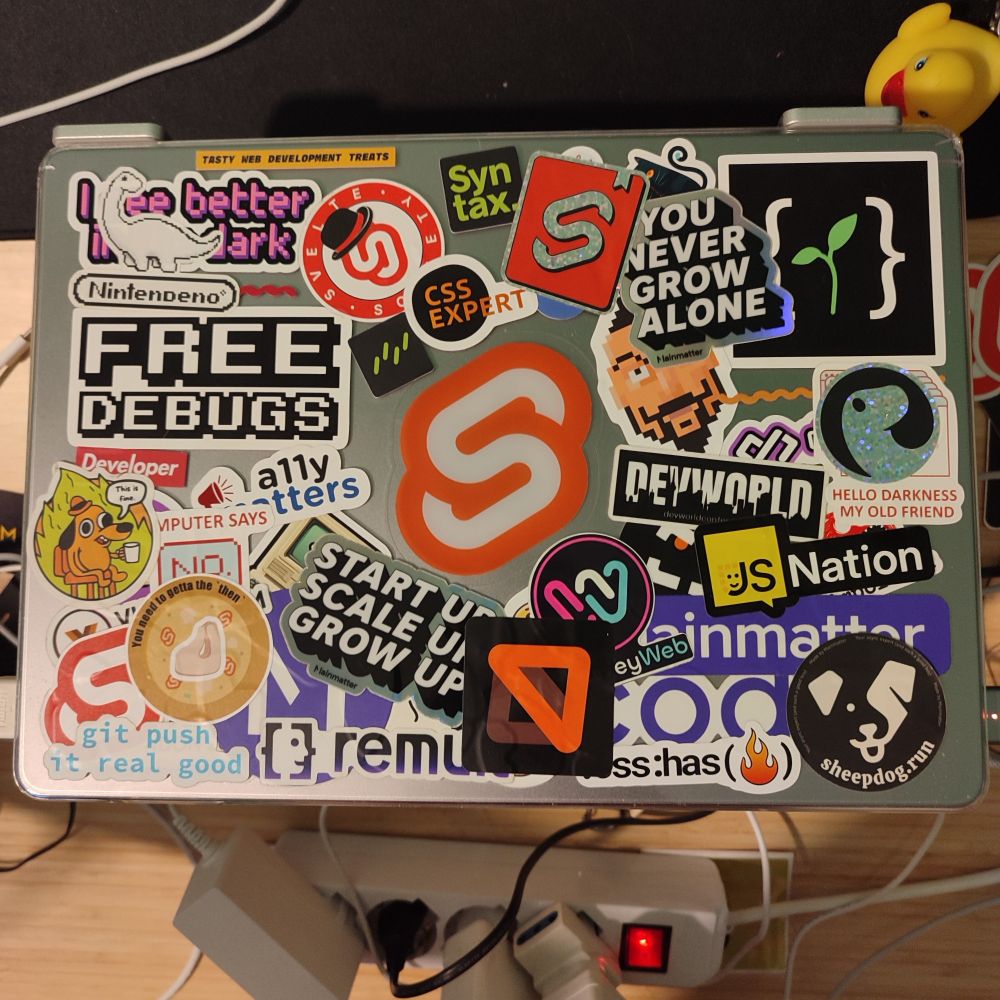 A laptop with a lot of stickers with a giant svelte logo in the middle