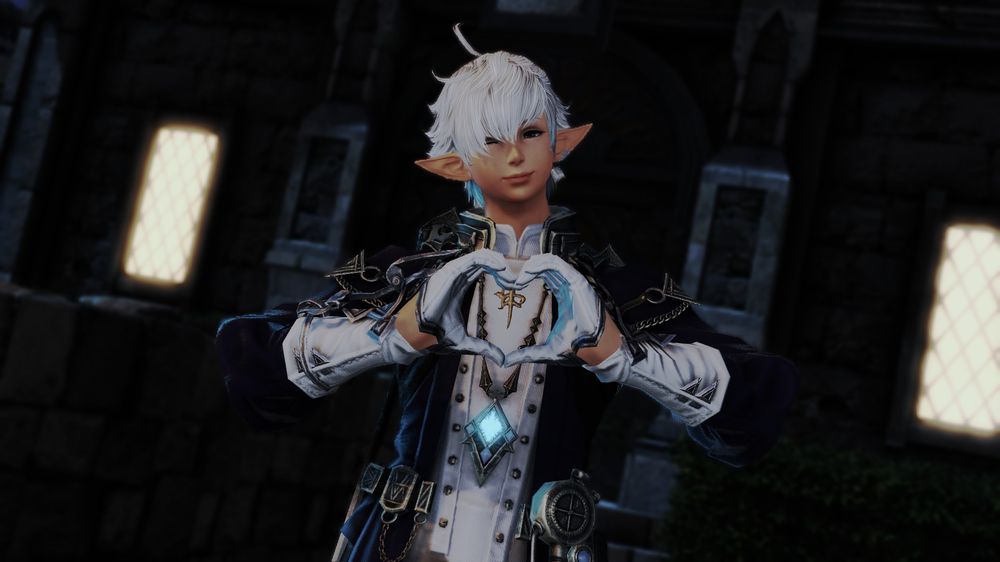 Alphinaud smiles at the viewer with a win, his hands in a heart-shape in front of him.