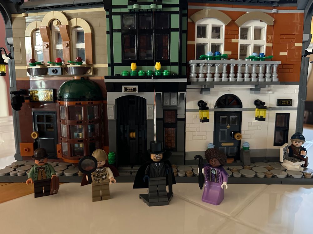 The Lego Sherlock Holmes Book Nook set expanded with the mini figures of Watson, Holmes, Moriarty, Irene and Paige standing in front. 