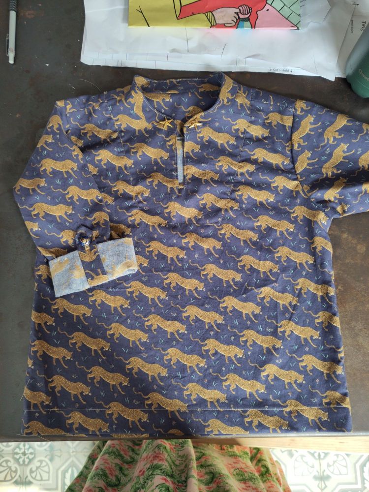 La même chemise, cette fois-ci dans un coton bleu foncé avec un motif répétitif de jaguars.