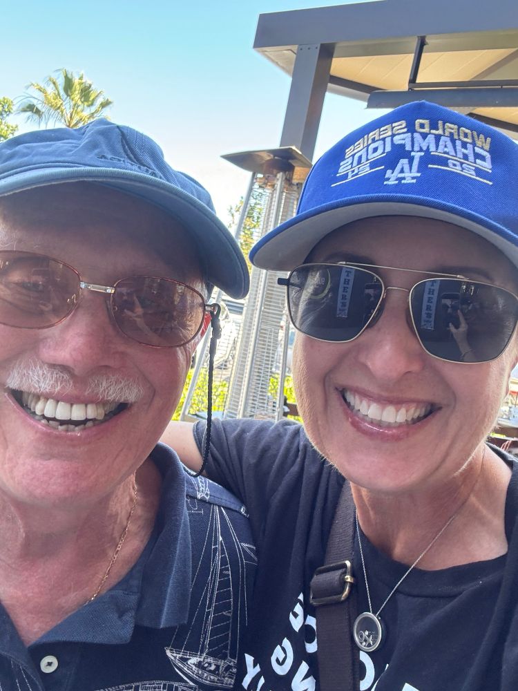 Picture of a woman in a Dodgers hat with her father. 