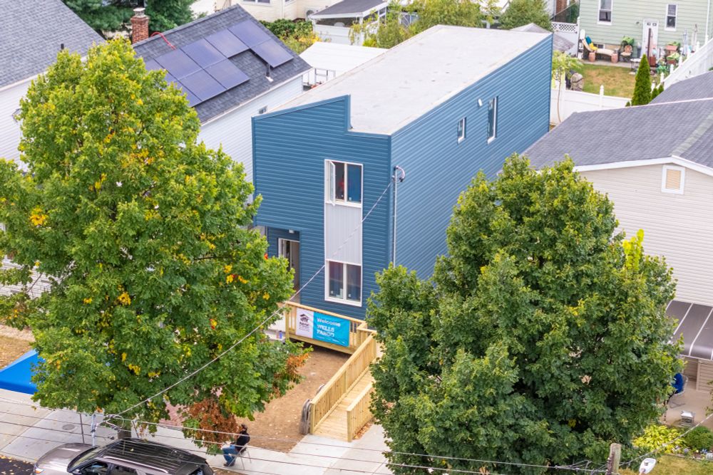 aerial shot of a modular Net Zero home with a wooden ramp leading to the front entrance