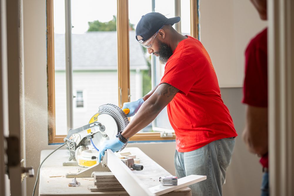 Wells Fargo volunteer using an electric circular saw to cut wood