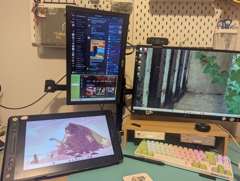 A photograph of Pipers desk, with three monitors. 