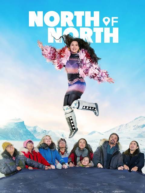 A young Inuk woman with long black hair, on a trampoline, bouncing in the air, with a pink and purple shaggy coat, a knit dress that resembles pink and purple mountains in its color bands, black leggings, and then white mukluk boots with grey seal fur and beads. Snow-covered mountains and a bright blue sky in the background. Villagers surround the trampoline in heavy winter wear (parkas, toboggans).