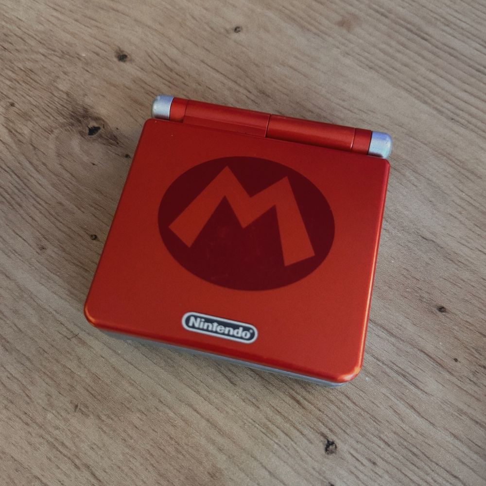 Foto a una gba sp cerrada edición especial mario sobre una mesa de madera