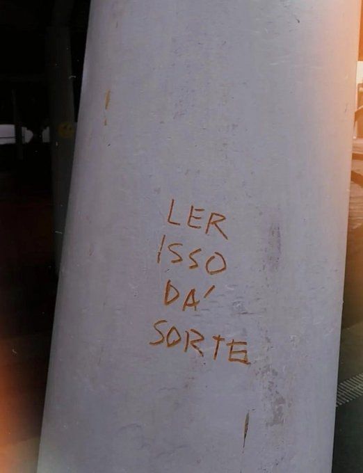 Foto de parede com frase escrita a mão "ler isso dá sorte"