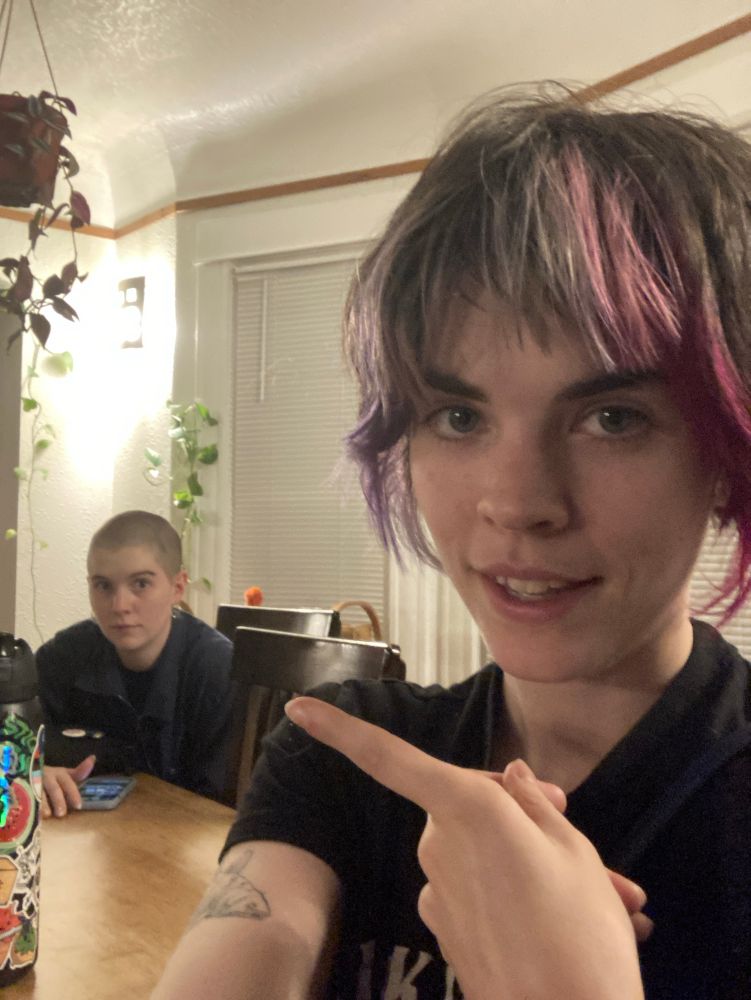 me looking like a moron smiling and pointing at my sister sitting in the background and giving a perfect deer in headlights expression 