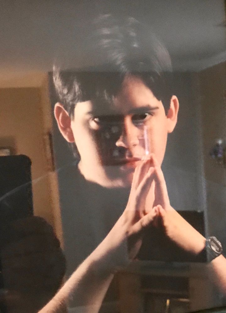 A person in a black shirt with a shadow over half their face