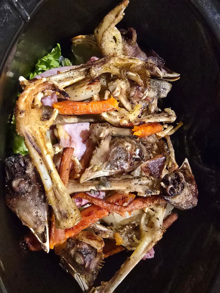 6 roasted chicken heads, their feet and veggies with herbs prepped for making rich, flavorful, and healthful chicken stock. 