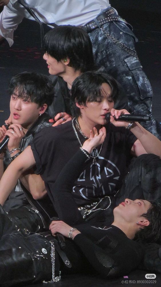 IN, changbin, and chan in a floor-pile onstage around lee know singing. chan is lying across lee know’s lap and reaching up to stroke his neck (he really has a thing for that hmm? much to think about)