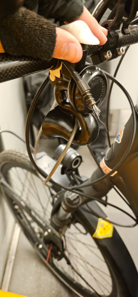 Man sieht ein Fahrrad Vorderrad und dessen Lenker. An der Kranzschaltung ist der Seilzug gerissen 