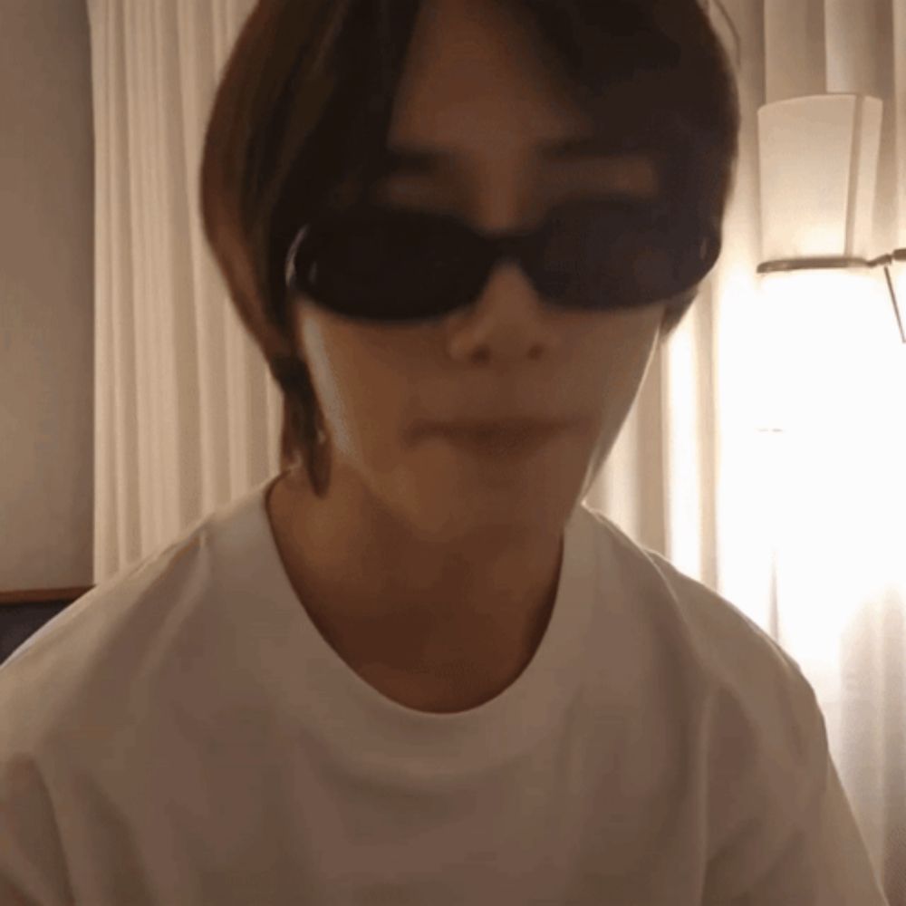 a young man wearing sunglasses and a white shirt