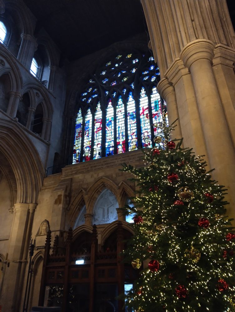 Photo of Christmas tree in front of west window in the nave of St Albans Cathedral 