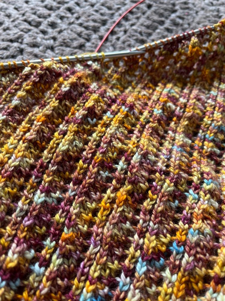Diagonal ribbed knitted lace in shades of gold, turquoise, plum. 