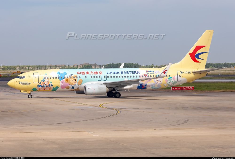 Chinese Eastern Airlines Boeing 737 in a light yellow and blue livery with cartoon characters